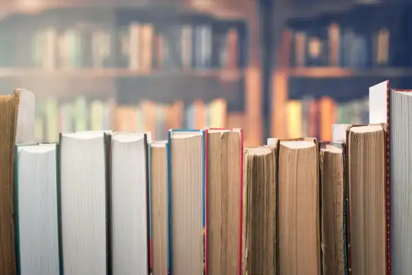 Rząd książek w zbliżeniu na tle biblioteki.